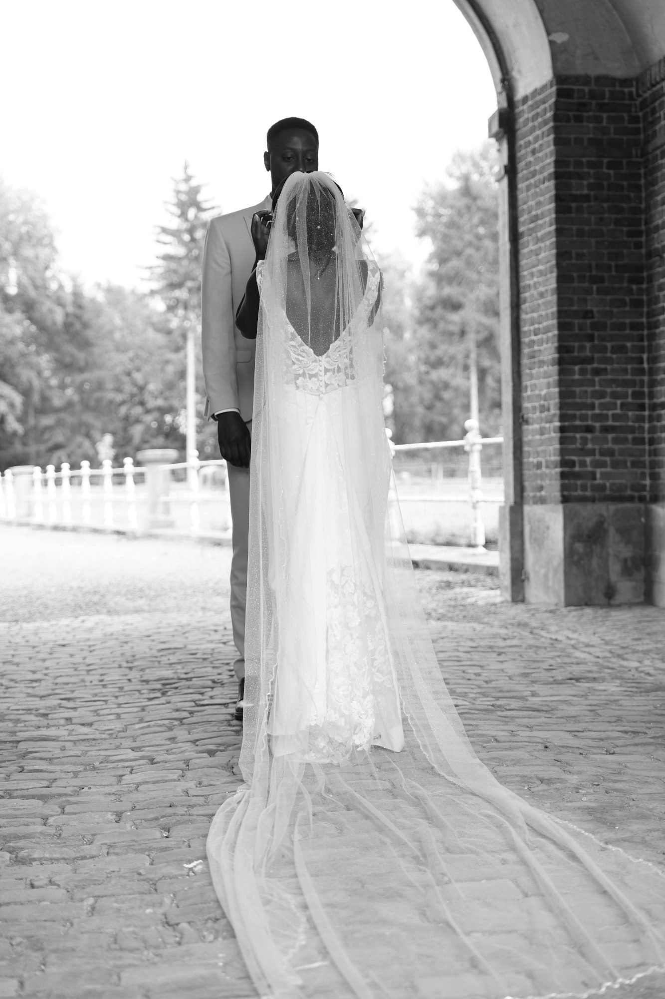 Premier regard des mariés sous le porche d'un château, mariage en province de Namur