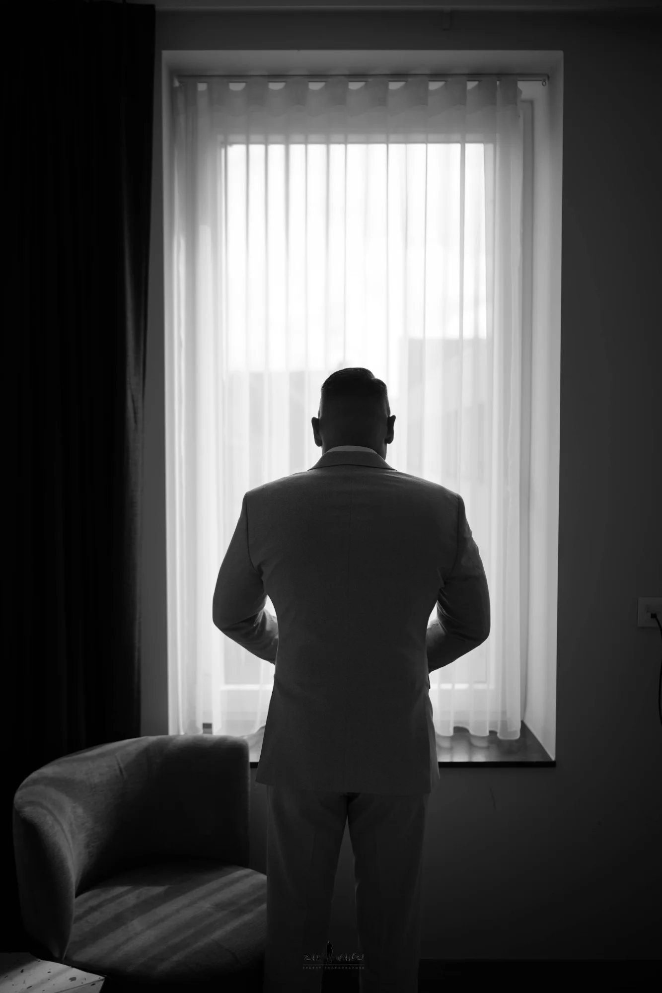 Le marié en silhouette devant la fenêtre pendant les préparatifs