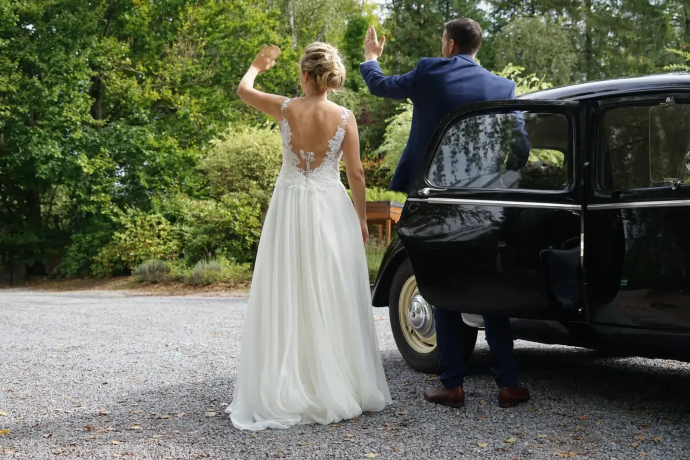 La mariée arrive devant la voiture ancienne