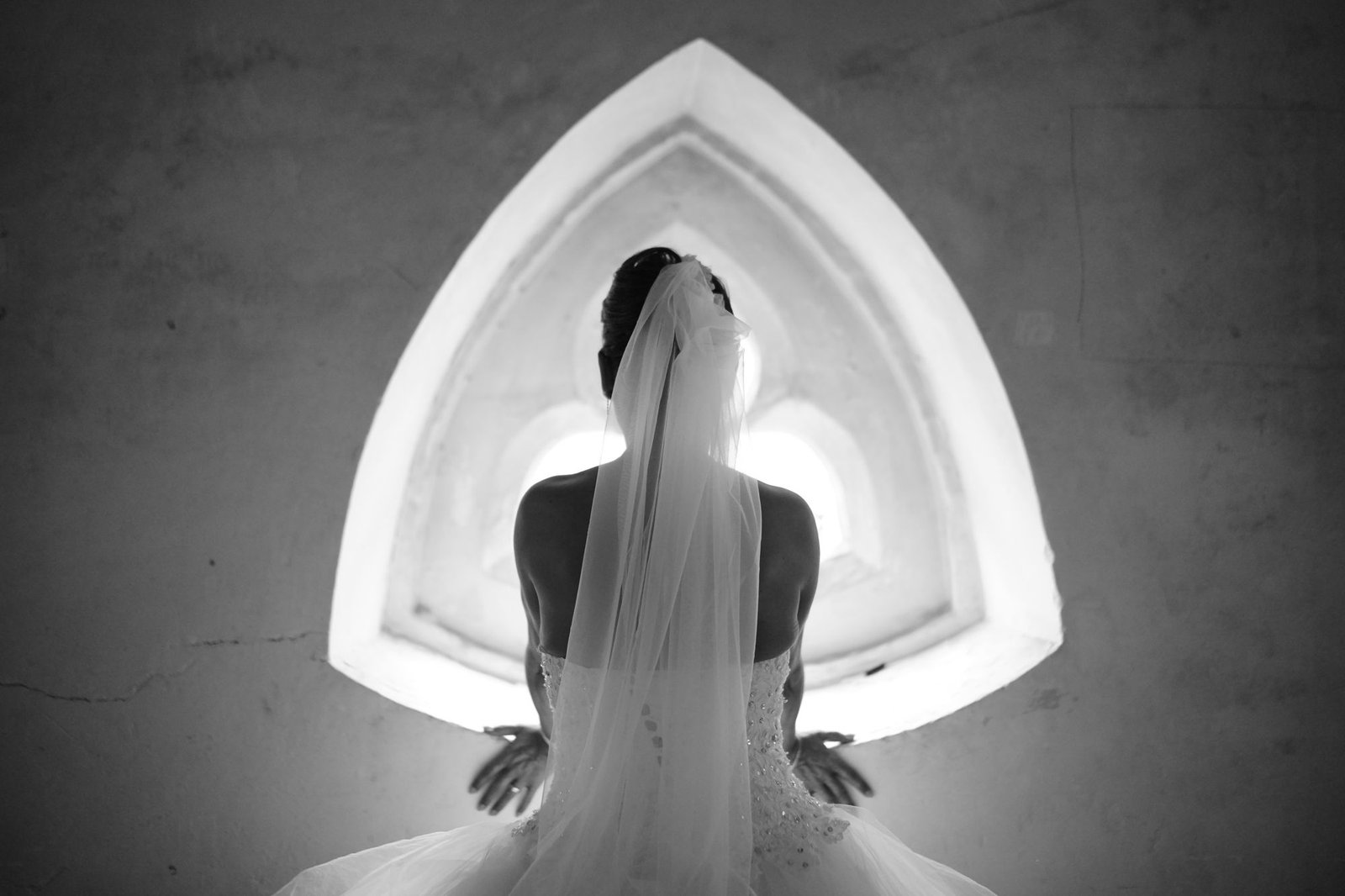 Mariée de dos devant une fenêtre gothique