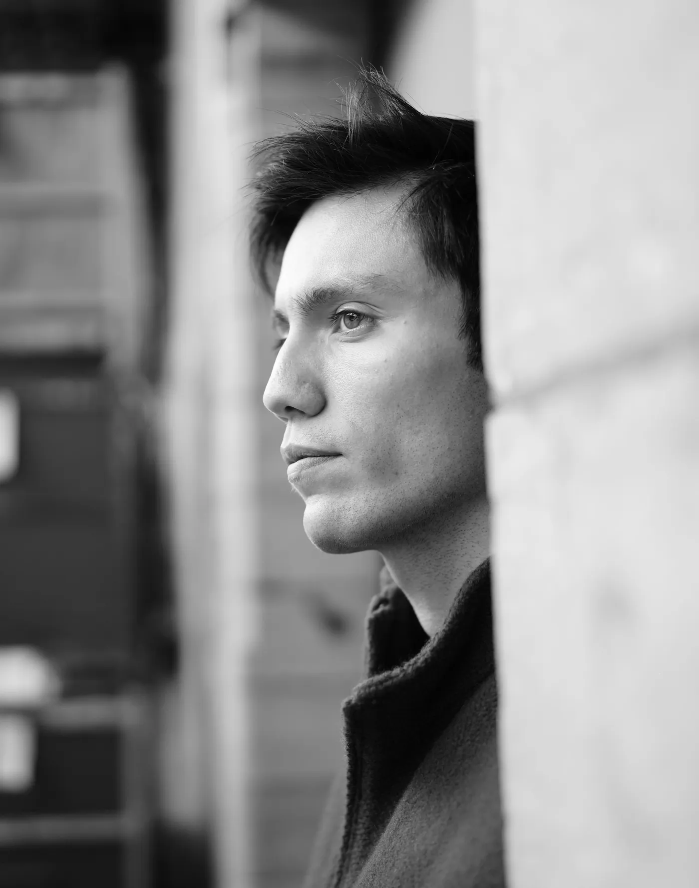 Portrait de profil en noir et blanc contre un mur
