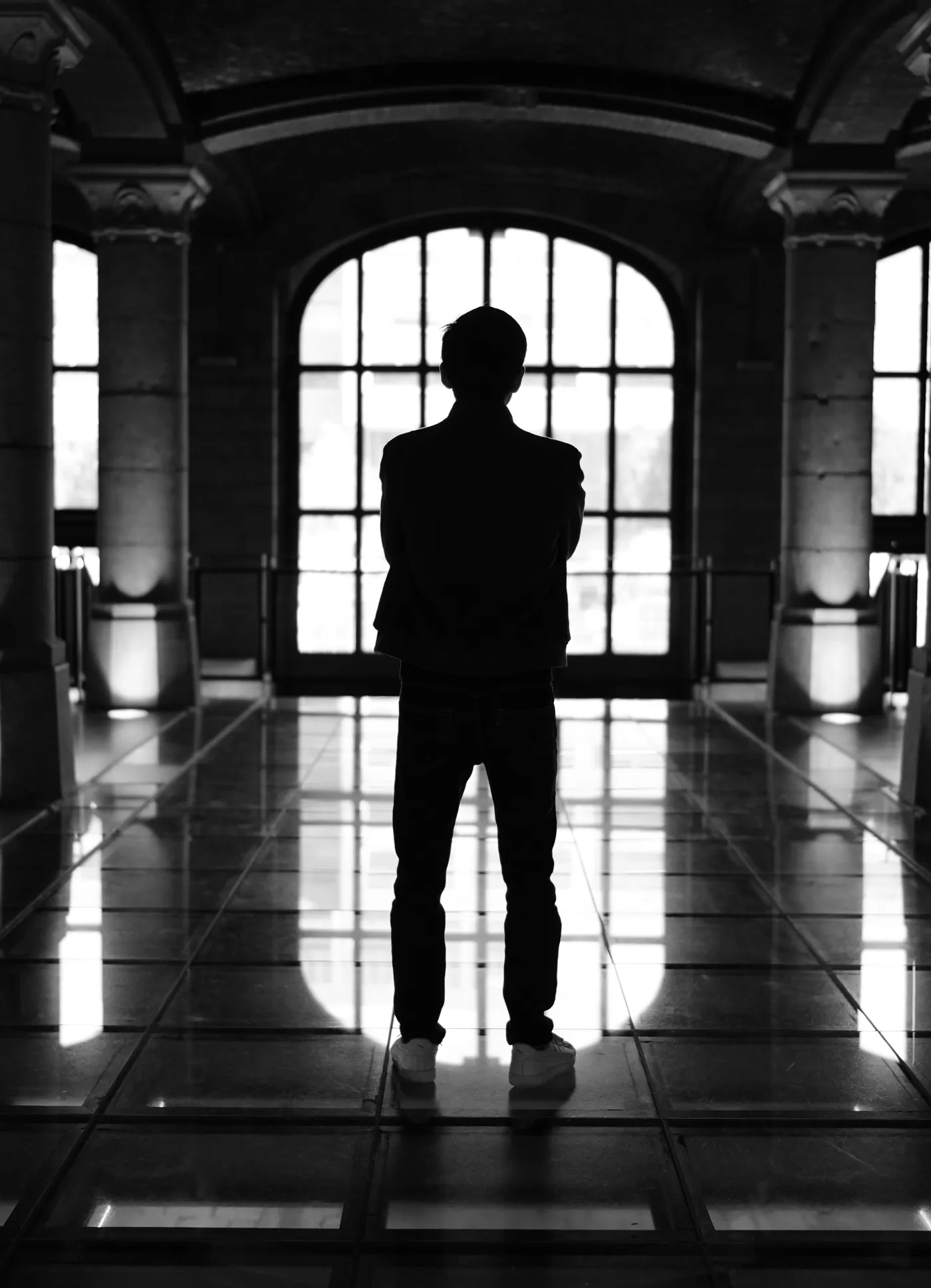 Silhouette à contre-jour devant une grande fenêtre